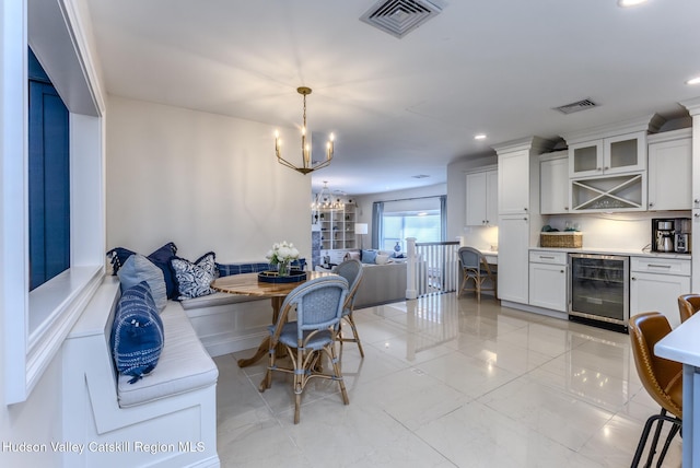 dining area featuring breakfast area, wine cooler, visible vents, and a notable chandelier