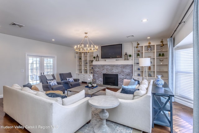 living room with visible vents, french doors, wood finished floors, and a glass covered fireplace