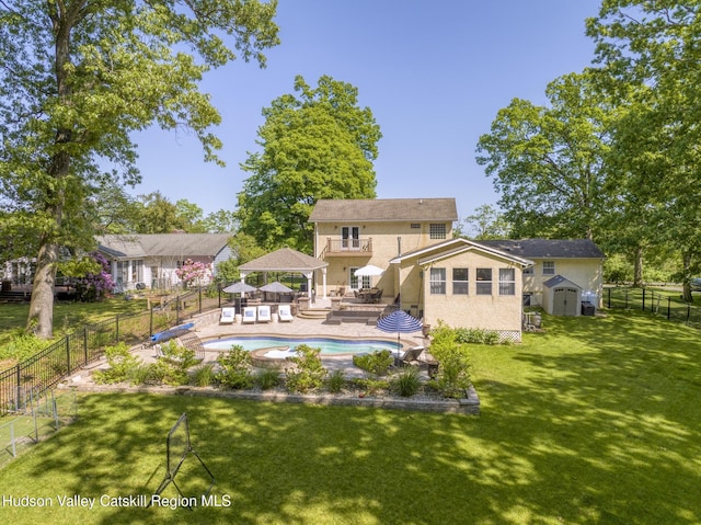 rear view of property with a fenced in pool, a yard, a gazebo, a fenced backyard, and an outdoor structure
