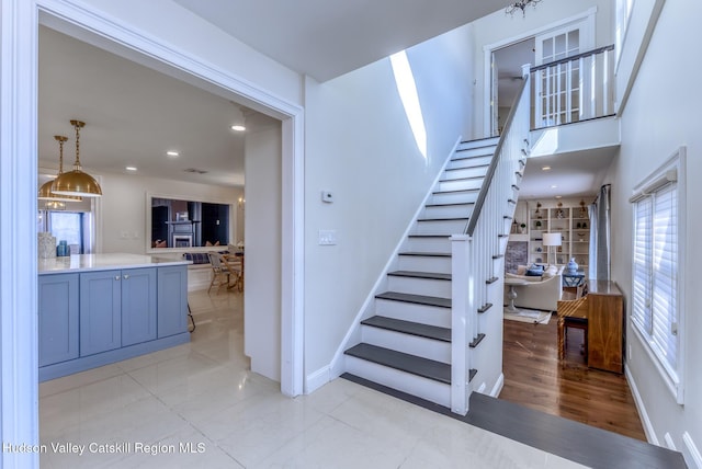 stairway featuring baseboards and recessed lighting