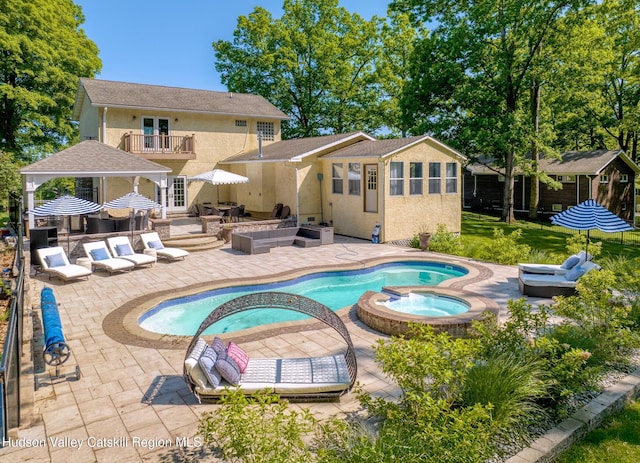 view of swimming pool featuring a patio, an outdoor hangout area, an outbuilding, a gazebo, and a pool with connected hot tub