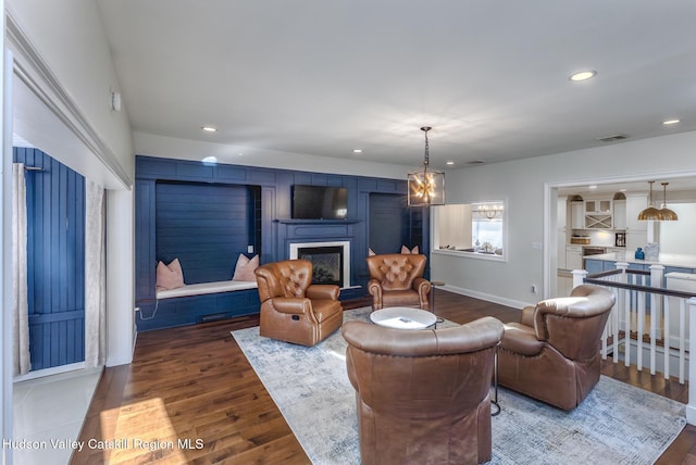 living area featuring dark wood-style flooring, a fireplace, visible vents, and recessed lighting