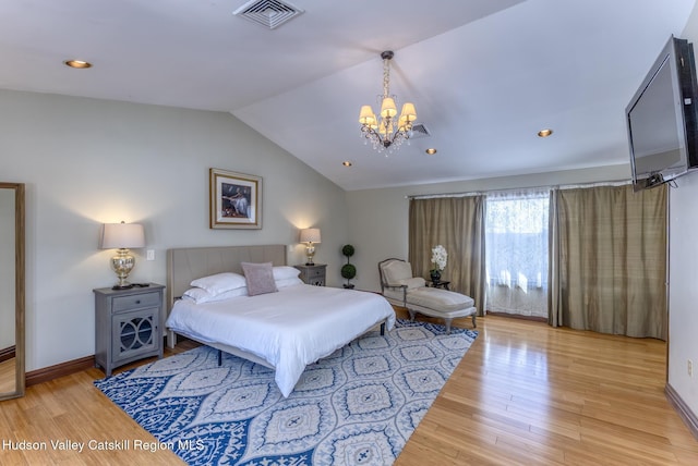 bedroom featuring vaulted ceiling, light wood finished floors, visible vents, and baseboards