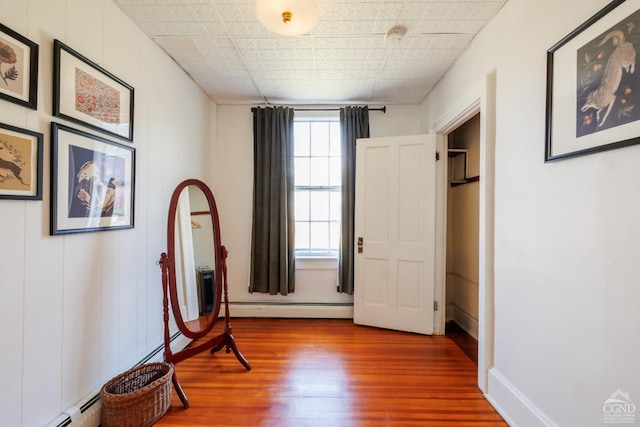 550-552 Columbia St, Hudson, NY 12534 - unfurnished bedroom featuring a baseboard heating unit, wood finished floors, baseboards, and a baseboard radiator