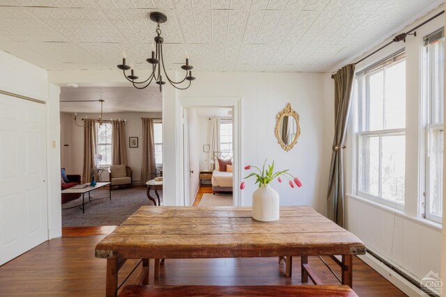 550-552 Columbia St, Hudson, NY 12534 - dining space featuring dark wood finished floors, a chandelier, and a baseboard radiator