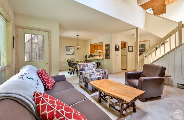 living area featuring light carpet and stairway