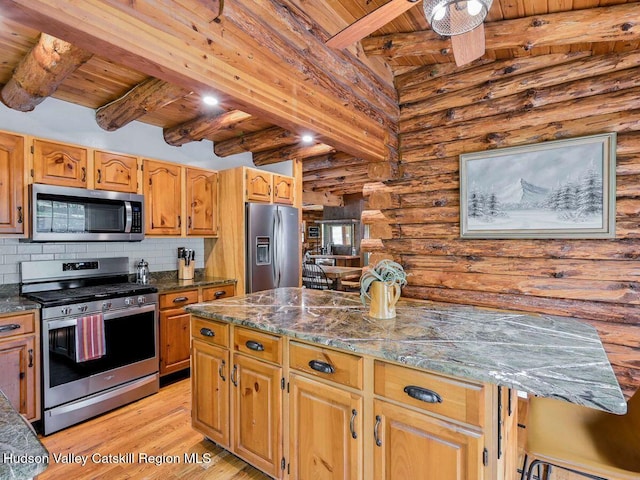 kitchen featuring dark stone counters, rustic walls, beamed ceiling, light hardwood / wood-style floors, and stainless steel appliances