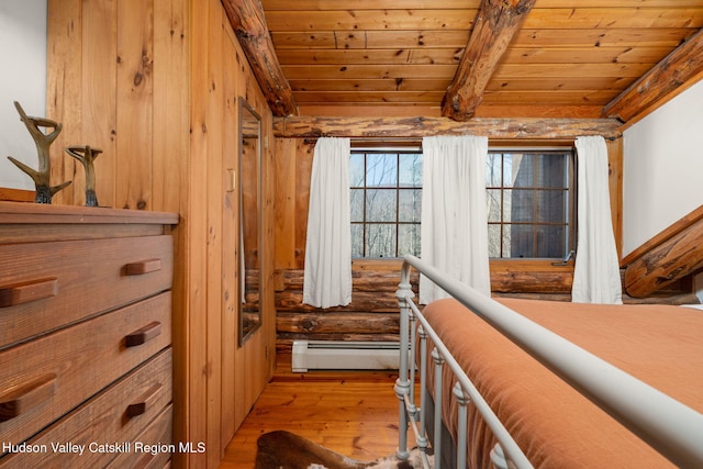 bedroom with wood walls, wooden ceiling, baseboard heating, beamed ceiling, and light hardwood / wood-style floors