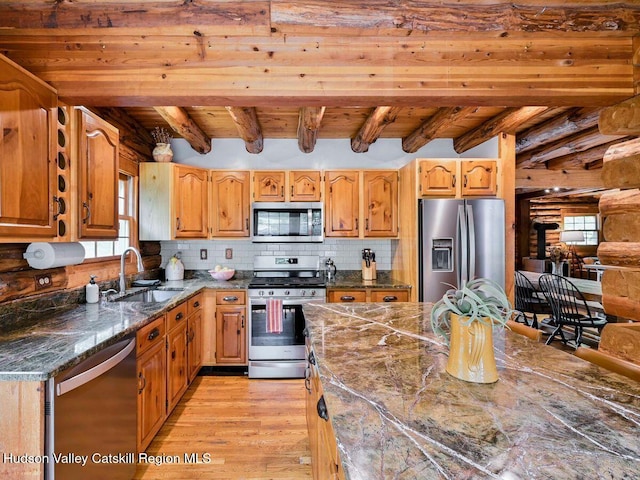 kitchen with appliances with stainless steel finishes, light wood-type flooring, wood ceiling, sink, and beam ceiling