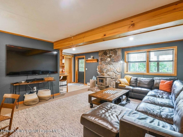 carpeted living room featuring a wood stove and crown molding