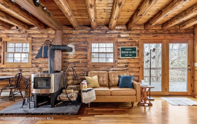 living room featuring a wood stove, wooden ceiling, beamed ceiling, and wood-type flooring