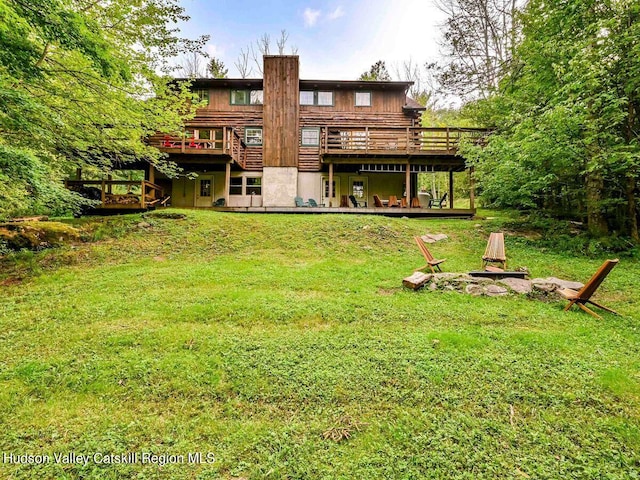 rear view of property featuring a wooden deck and a yard