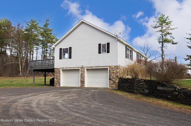 186 Meadow Brook Ln, Greenville, NY 12083 - view of side of home featuring stone siding, a garage, and driveway