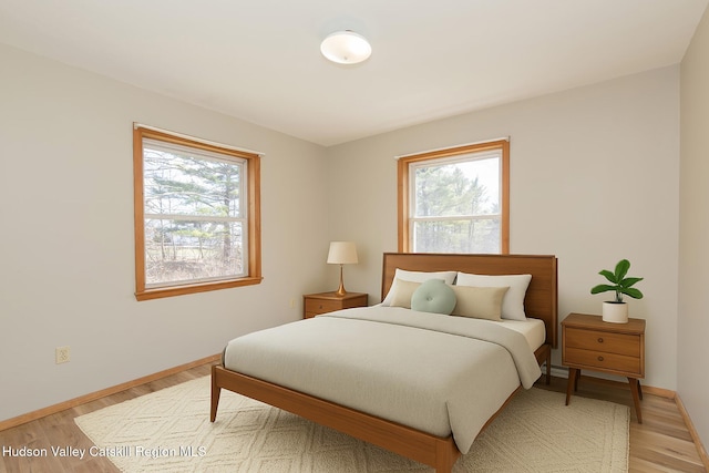 186 Meadow Brook Ln, Greenville, NY 12083 - bedroom featuring multiple windows, baseboards, and light wood finished floors