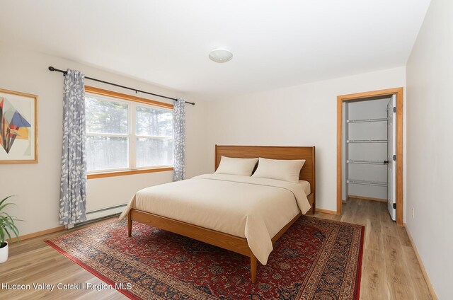 186 Meadow Brook Ln, Greenville, NY 12083 - bedroom featuring light wood finished floors, baseboards, a baseboard radiator, and a spacious closet