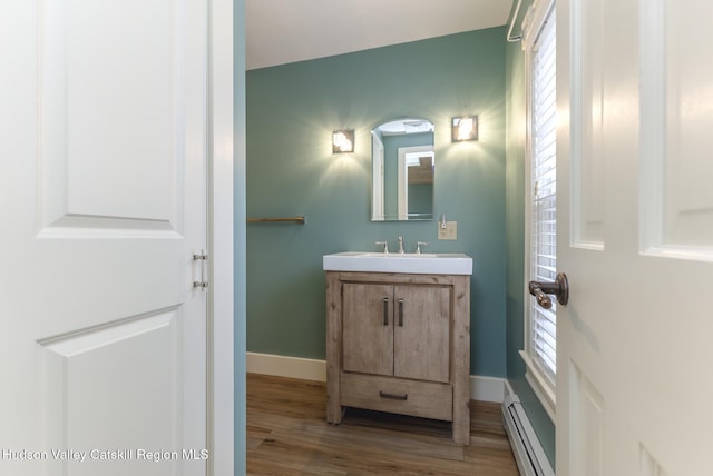 bathroom with vanity, baseboard heating, and hardwood / wood-style flooring