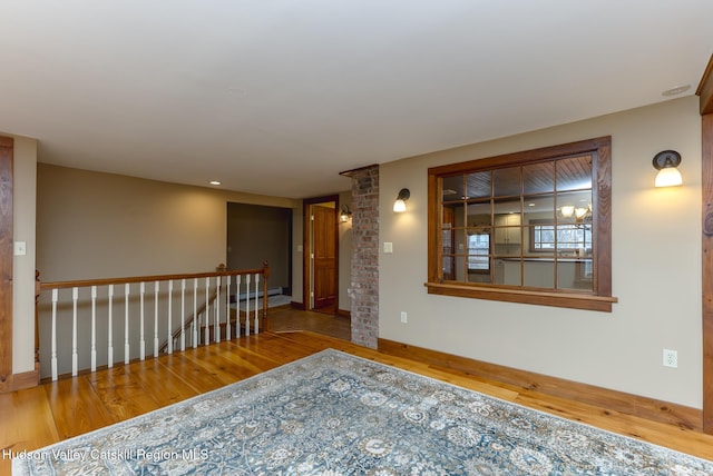 spare room with baseboard heating and hardwood / wood-style flooring