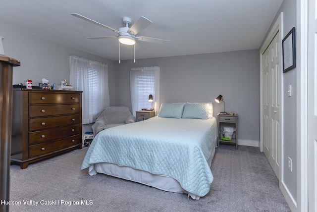 bedroom featuring light carpet, ceiling fan, and a closet