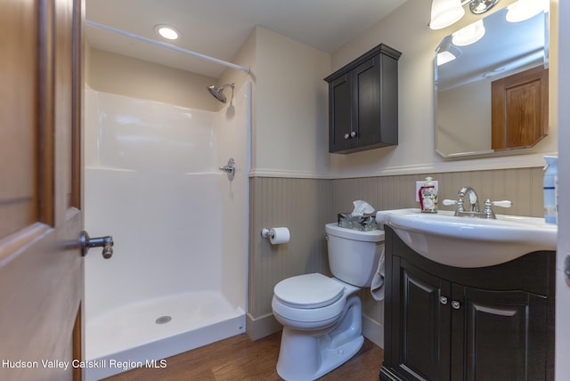 bathroom featuring toilet, walk in shower, hardwood / wood-style flooring, and vanity