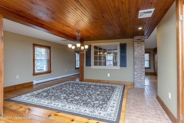 unfurnished dining area with a baseboard heating unit, ornate columns, and a notable chandelier