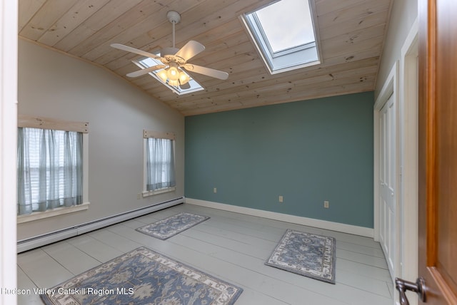 spare room featuring ceiling fan, baseboard heating, wood ceiling, and vaulted ceiling with skylight