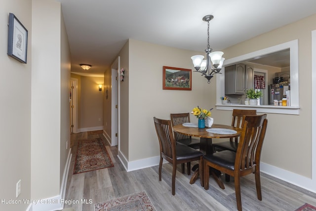 dining room featuring light hardwood / wood-style floors and a notable chandelier