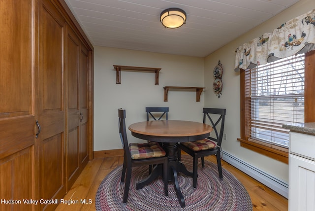 dining room featuring baseboard heating and light hardwood / wood-style floors