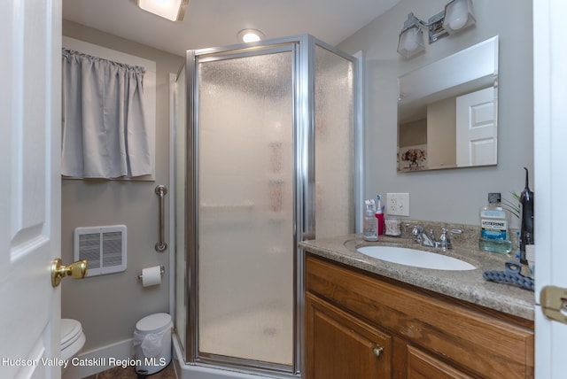 bathroom with toilet, a shower with shower door, and vanity