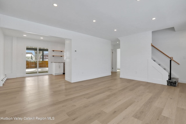 unfurnished living room with stairway, light wood-type flooring, a baseboard radiator, and recessed lighting