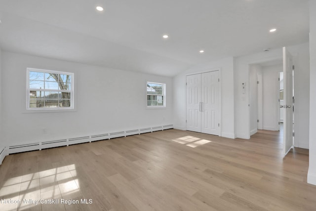 unfurnished room featuring light wood finished floors, a baseboard heating unit, and recessed lighting