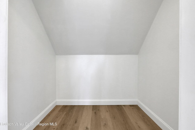 bonus room featuring lofted ceiling, baseboards, and wood finished floors