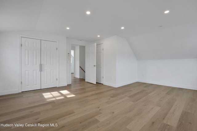 additional living space with recessed lighting, baseboards, vaulted ceiling, and light wood finished floors