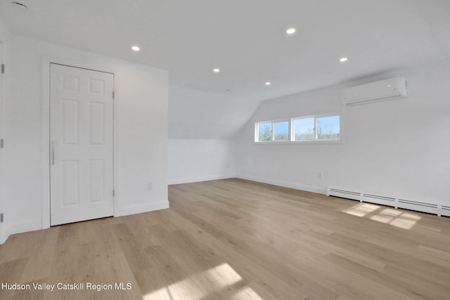 additional living space featuring recessed lighting, baseboards, a wall unit AC, and light wood finished floors