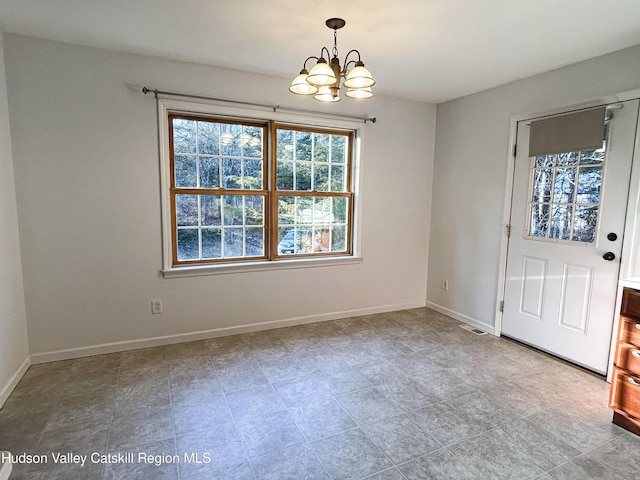 unfurnished dining area featuring a notable chandelier