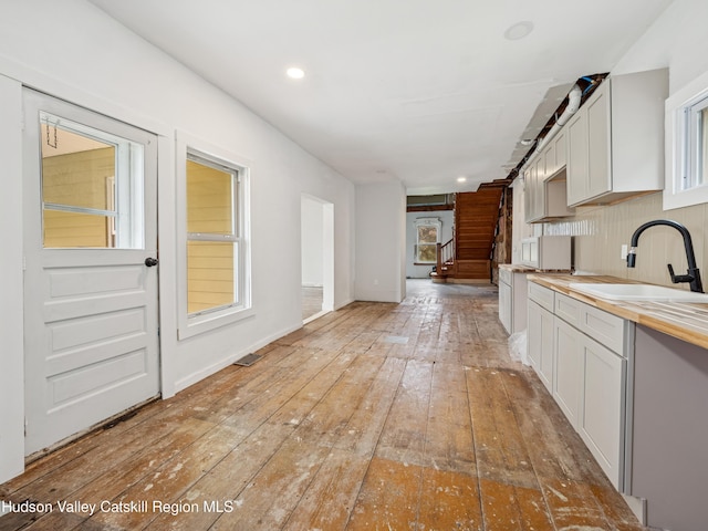 125 Water St, Franklin, NY 13775 - kitchen featuring a sink, butcher block counters, light wood-style flooring, white cabinetry, and recessed lighting