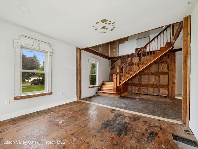 125 Water St, Franklin, NY 13775 - unfurnished living room featuring healthy amount of natural light, stairs, hardwood / wood-style flooring, and baseboards