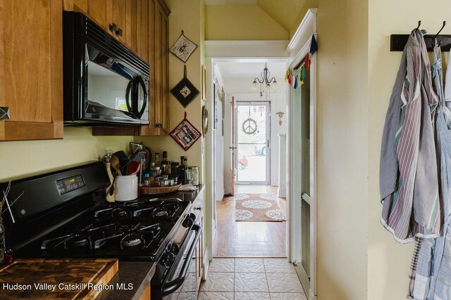 15 Mckinstry Pl, Hudson, NY 12534 - kitchen with gas stove, black microwave, brown cabinetry, and dark countertops