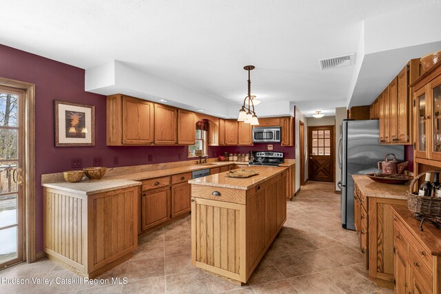 4 Mountain View Dr, Kerhonkson, NY 12446 - kitchen featuring stainless steel appliances, a center island, a sink, brown cabinets, and healthy amount of natural light