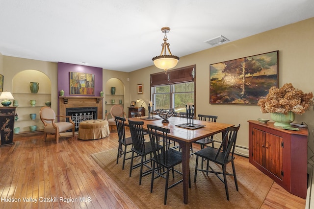 4 Mountain View Dr, Kerhonkson, NY 12446 - dining area featuring a fireplace, arched walkways, light wood-type flooring, and built in features