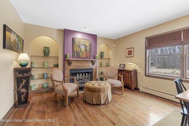 4 Mountain View Dr, Kerhonkson, NY 12446 - sitting room with a baseboard radiator, hardwood / wood-style floors, a fireplace, and built in features