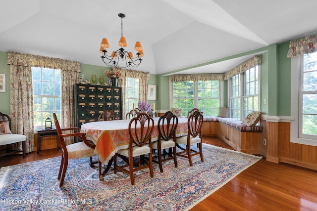 dining room featuring hardwood / wood-style flooring, an inviting chandelier, a wealth of natural light, and lofted ceiling