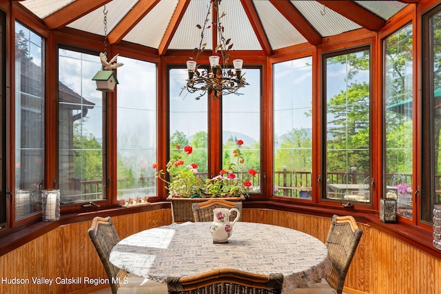 sunroom / solarium with lofted ceiling with beams and an inviting chandelier