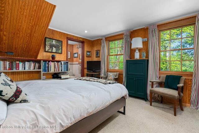 carpeted bedroom featuring wooden walls