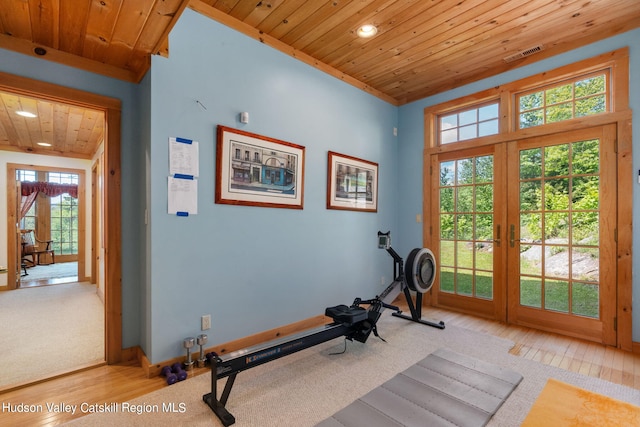 workout room featuring french doors, light wood-type flooring, plenty of natural light, and wooden ceiling