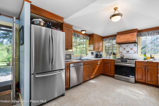 kitchen featuring sink, appliances with stainless steel finishes, lofted ceiling, light tile patterned floors, and custom exhaust hood