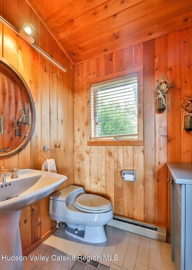 490 Mill St, Windham, NY 12496 - half bathroom featuring a baseboard heating unit, tile patterned flooring, wood walls, and wooden ceiling