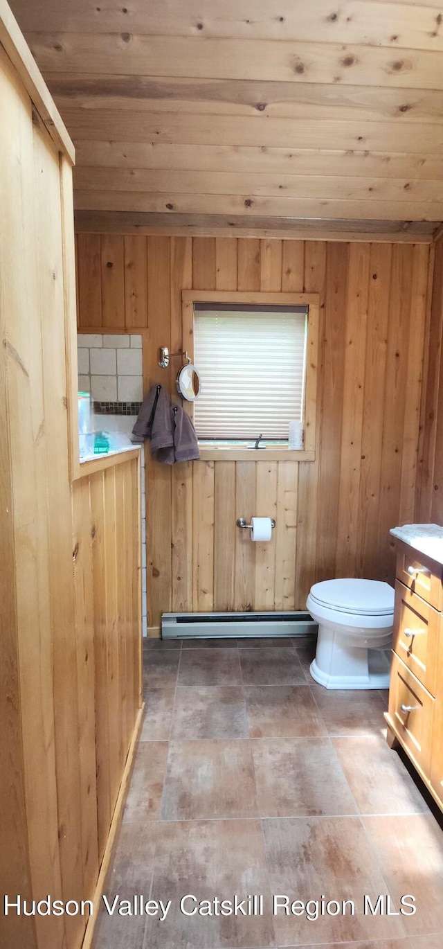 490 Mill St, Windham, NY 12496 - bathroom with a baseboard heating unit, wooden ceiling, vanity, and wooden walls