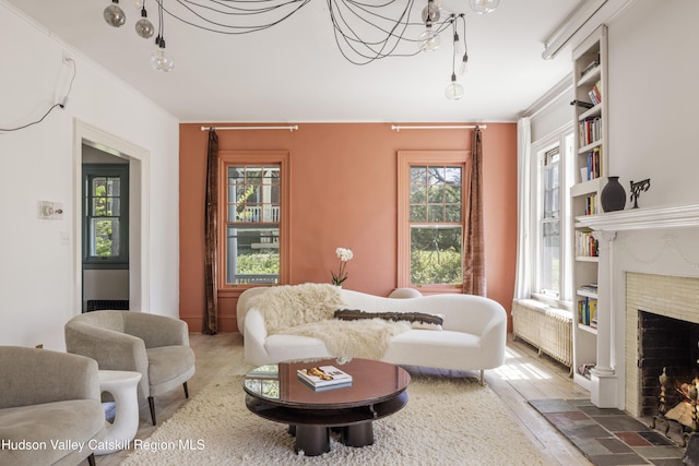 131 William St, Catskill, NY 12414 - living room featuring radiator, wood finished floors, healthy amount of natural light, built in features, and ornamental molding