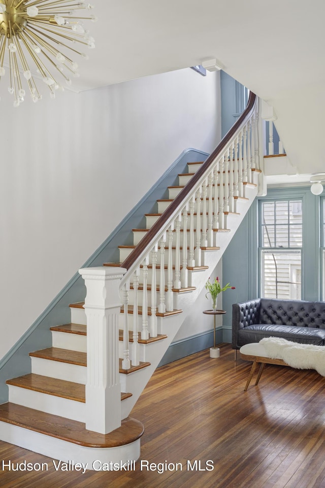 131 William St, Catskill, NY 12414 - stairway featuring hardwood / wood-style flooring, a chandelier, and baseboards