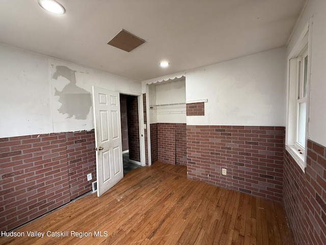 22 Cedar St, Saugerties, NY 12477 - spare room featuring hardwood / wood-style flooring and brick wall
